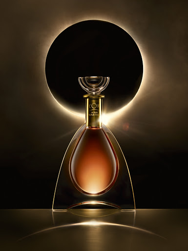 A luxury liquor bottle with gold accents is displayed against a glowing circular backdrop, creating an elegant and high-end aesthetic.