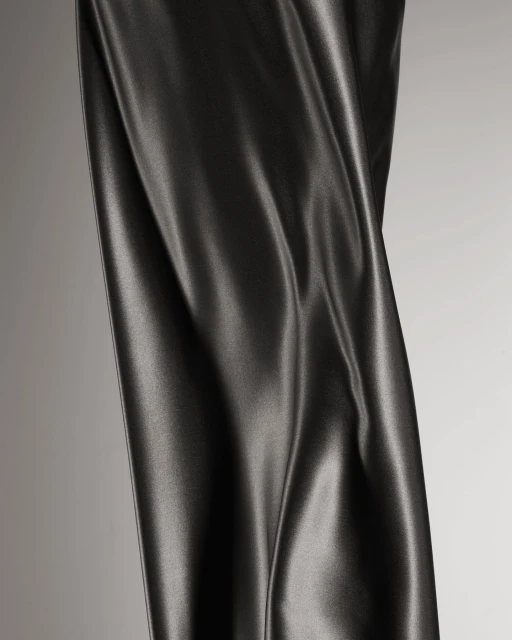 Black leather textile swatch with draping folds and texture detail under studio lighting, neutral grey background, product shot, high detail.