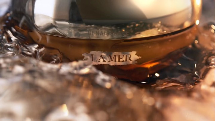 La Mer product shot features the brand's cream submerged in water with golden undertones, highlighting its luxury skincare appeal.