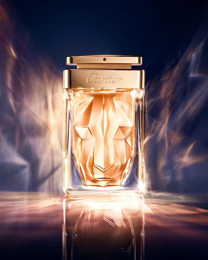 Close-up studio shot of a gold-toned Cartier La Panthère perfume bottle featuring a faceted panther face design and gold cap and collar.