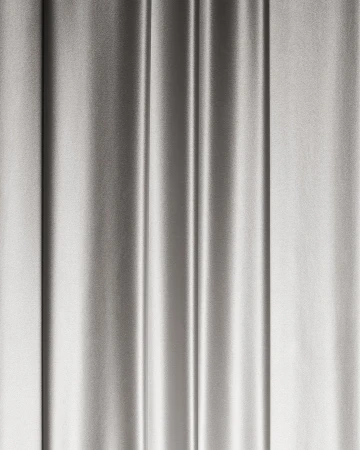 Elegant silver satin fabric drapes vertically with soft folds and subtle sheen, perfect for backdrops and luxurious textures.
