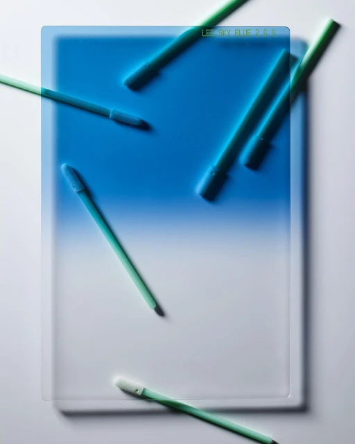 Abstract image features a gradient filter with a blue and white blend, accompanied by green cleaning wands spread across the surface.
