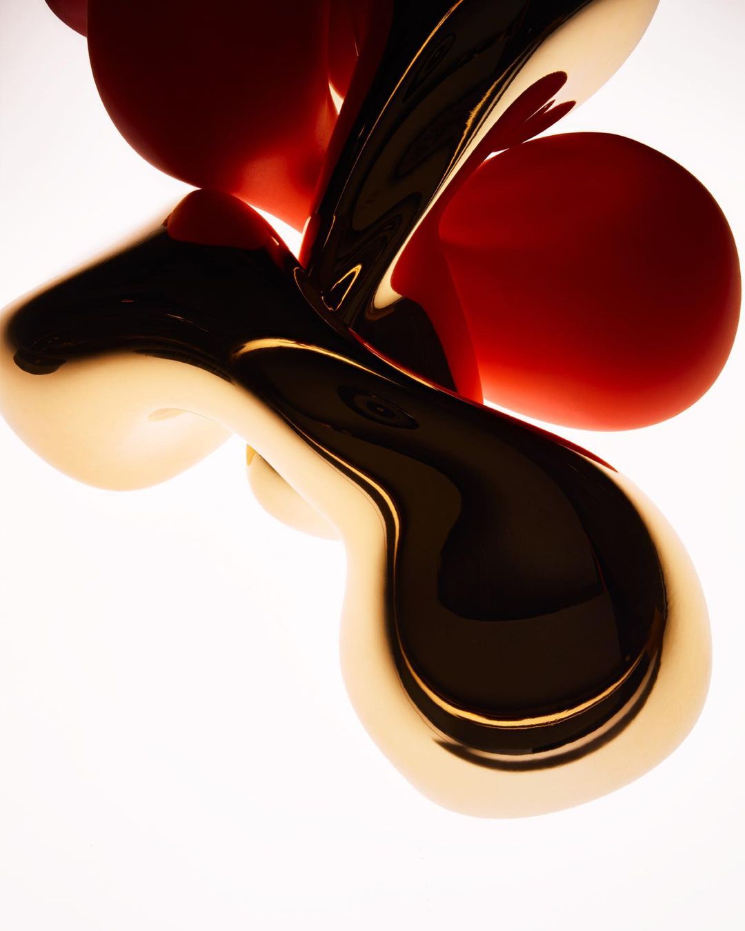 Abstract sculpture with metallic gold curves and red sphere shapes, studio lighting, sleek textures, and smooth surfaces on white.