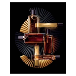 Several glass perfume bottles with amber liquid arranged over a black and gold sunburst pleated background.