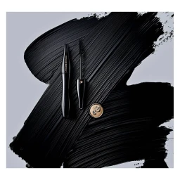 Black mascara tube and wand displayed over thick black brushstrokes against a pale grey background.