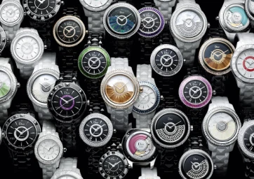 A close-up collection of luxury ceramic and diamond-set Dior wristwatches arranged closely together against a dark background.