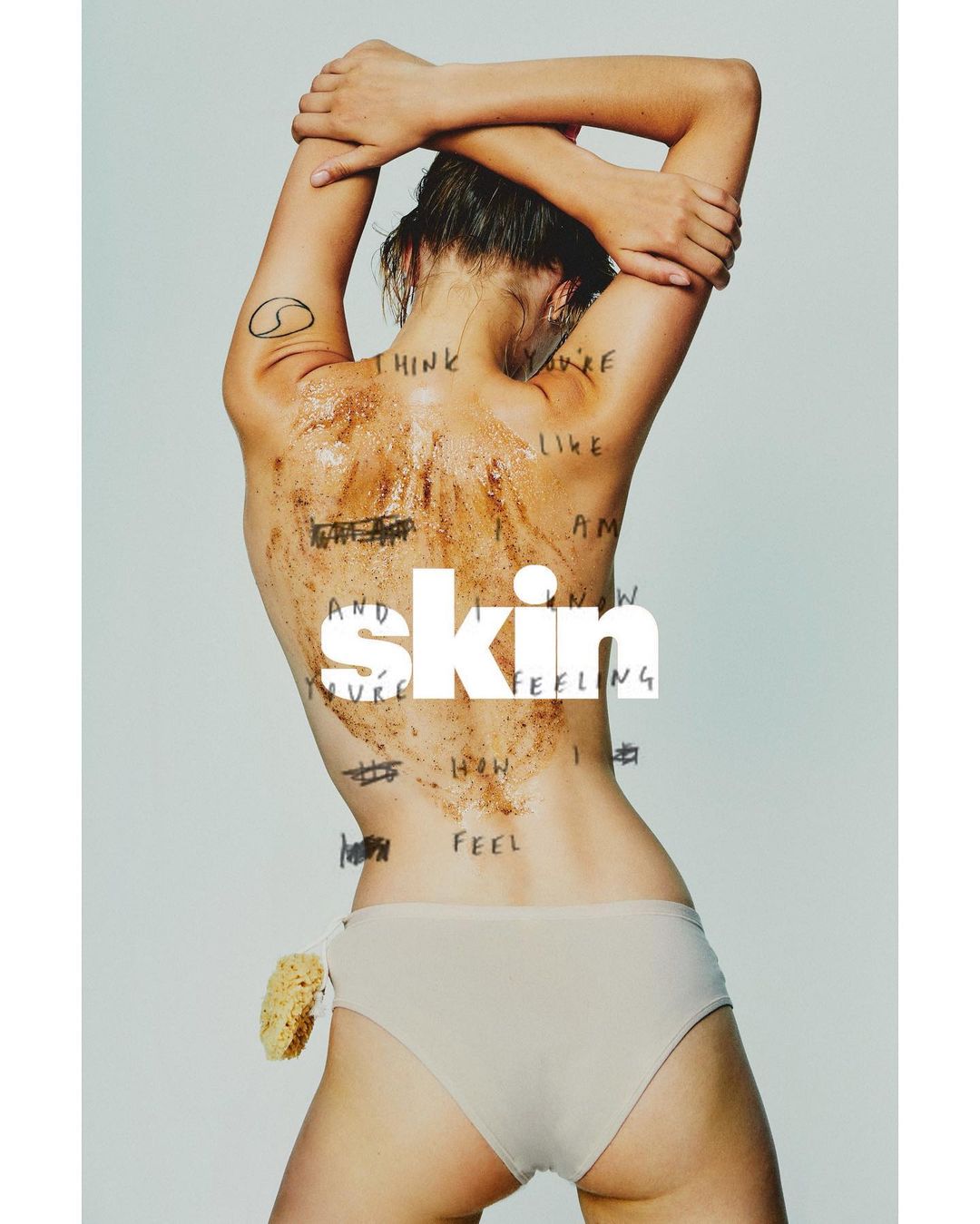 Woman with body scrub stands with arms raised. The word 'skin' is overlaid on her mid back. Body scrub and handwritten text detail her back.