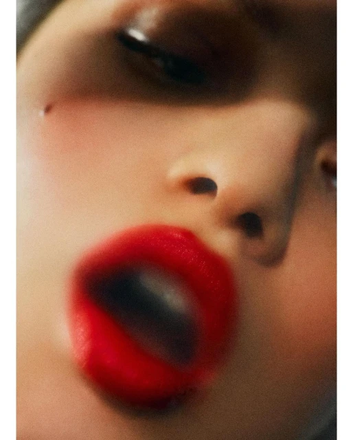Close-up portrait of a woman's face featuring red lipstick, selective focus and soft lighting. Beauty and cosmetic concept.