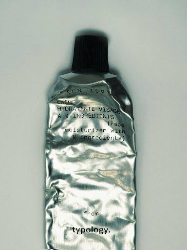 Silver cosmetic tube of face moisturizer with black cap, with french and english text, close-up product shot for beauty and skin care.