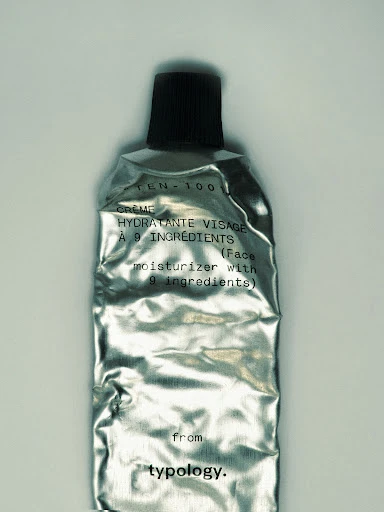 Silver cosmetic tube of face moisturizer with black cap, with french and english text, close-up product shot for beauty and skin care.