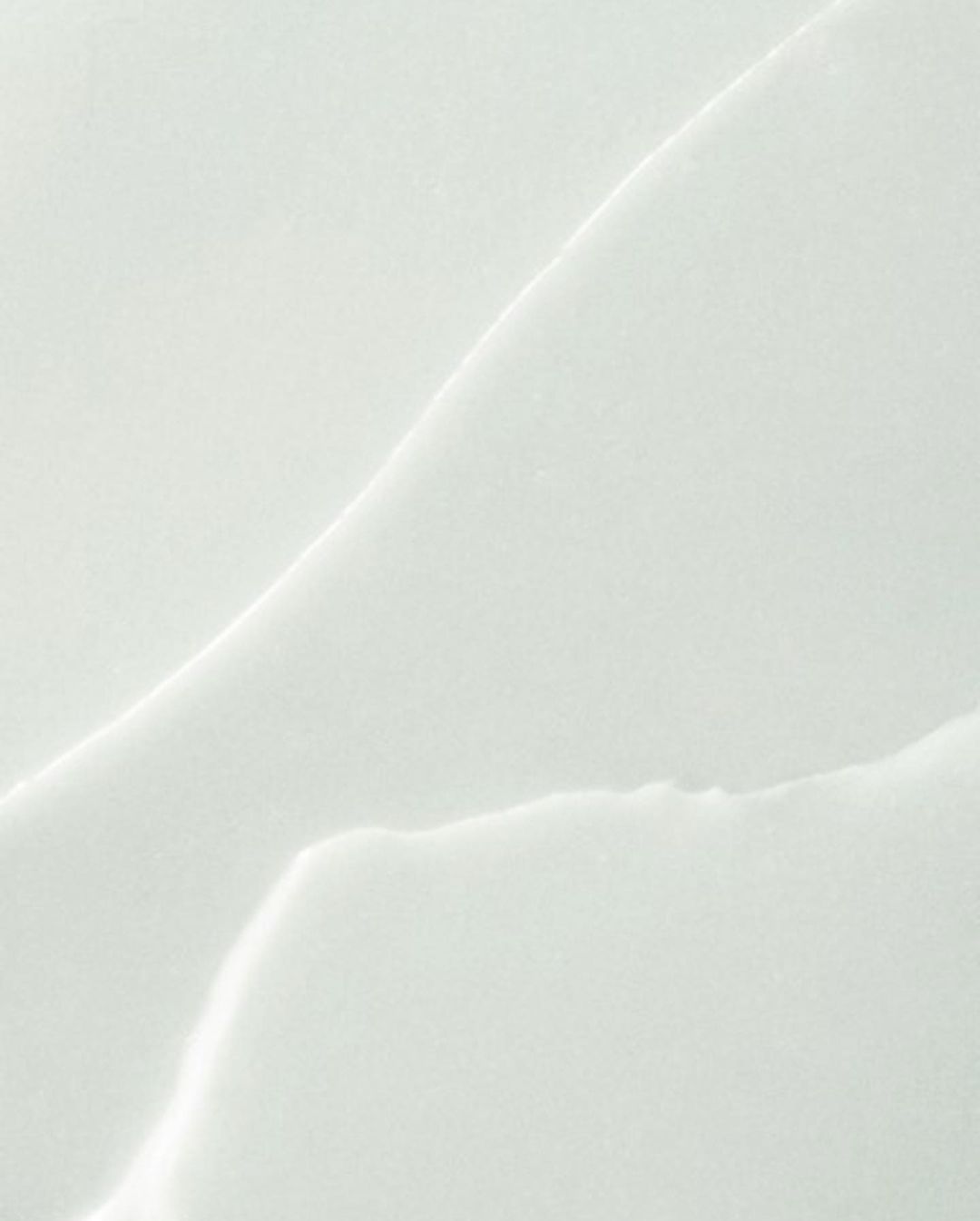 Close-up abstract texture of white marble slab with natural-looking vein patterns for use as a background, template, or design element.