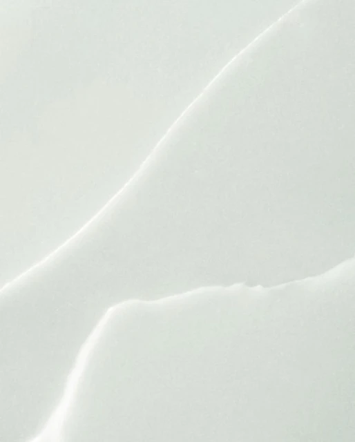 Close-up abstract texture of white marble slab with natural-looking vein patterns for use as a background, template, or design element.