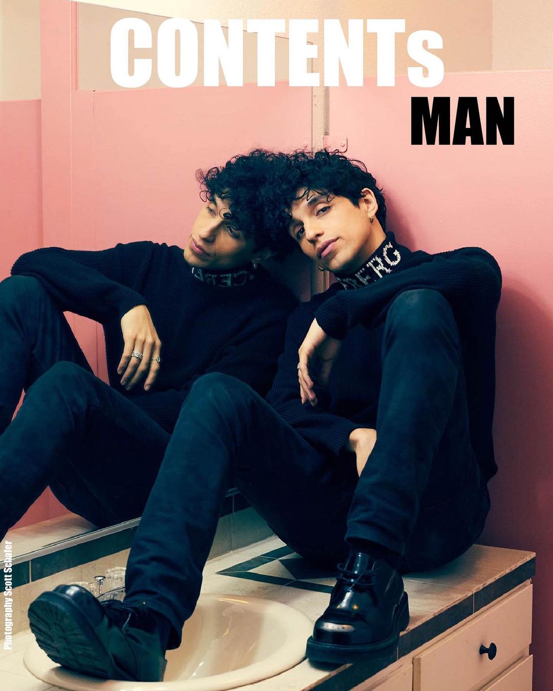 Magazine cover featuring a young adult male with dark curly hair in a black turtleneck and jeans, posed in front of a pink tiled wall.