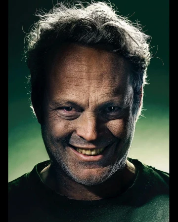 Close-up portrait of actor Vince Vaughn smiling with intense expression under dramatic low-key lighting