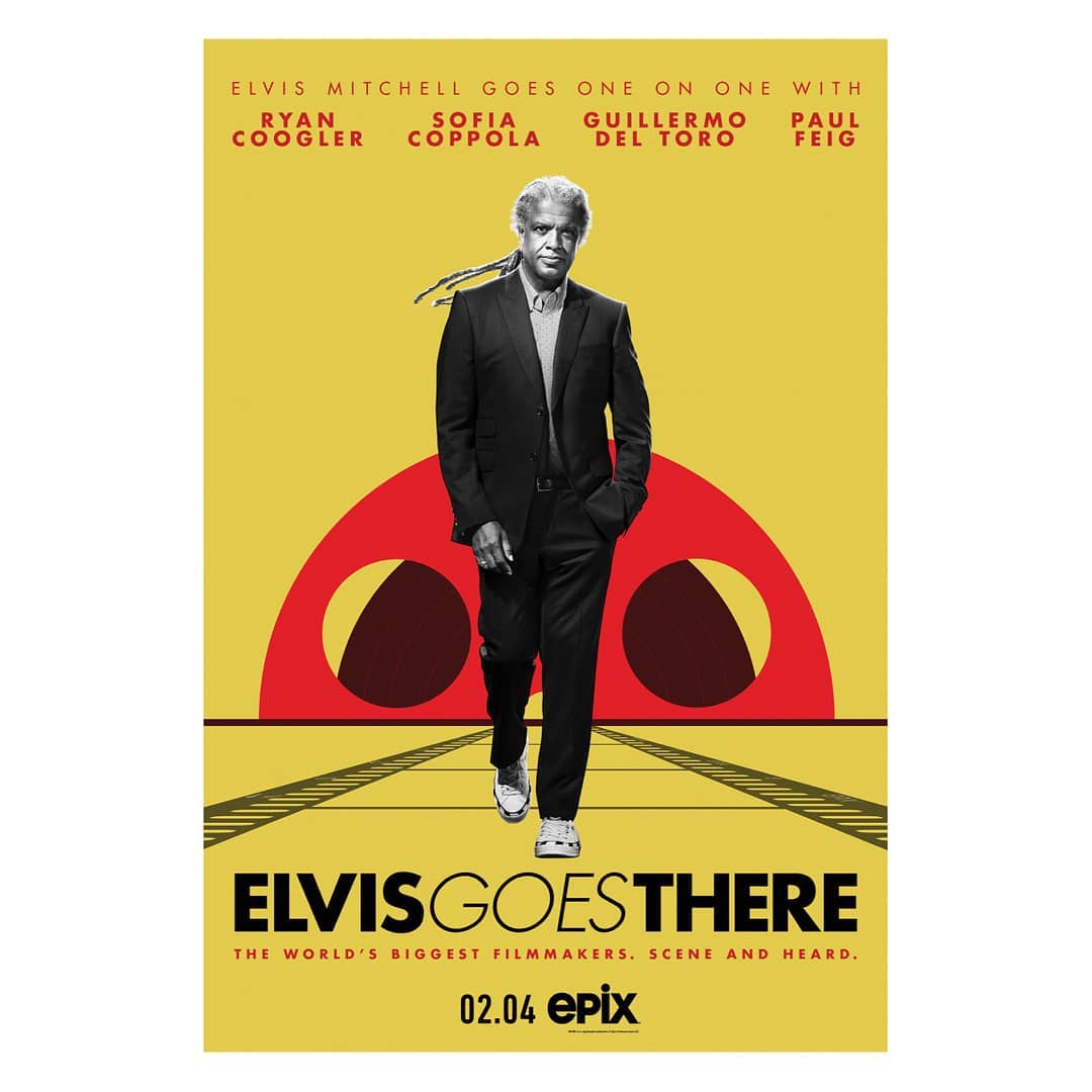 Movie poster for 'Elvis Goes There' featuring Elvis Mitchell walking along railroad tracks with a yellow and red background design.