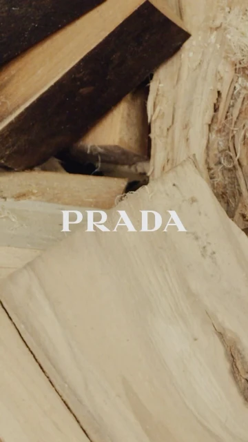 Angled view of natural wood planks featuring the Prada logo, showcasing a minimalist style with focus on texture and form.
