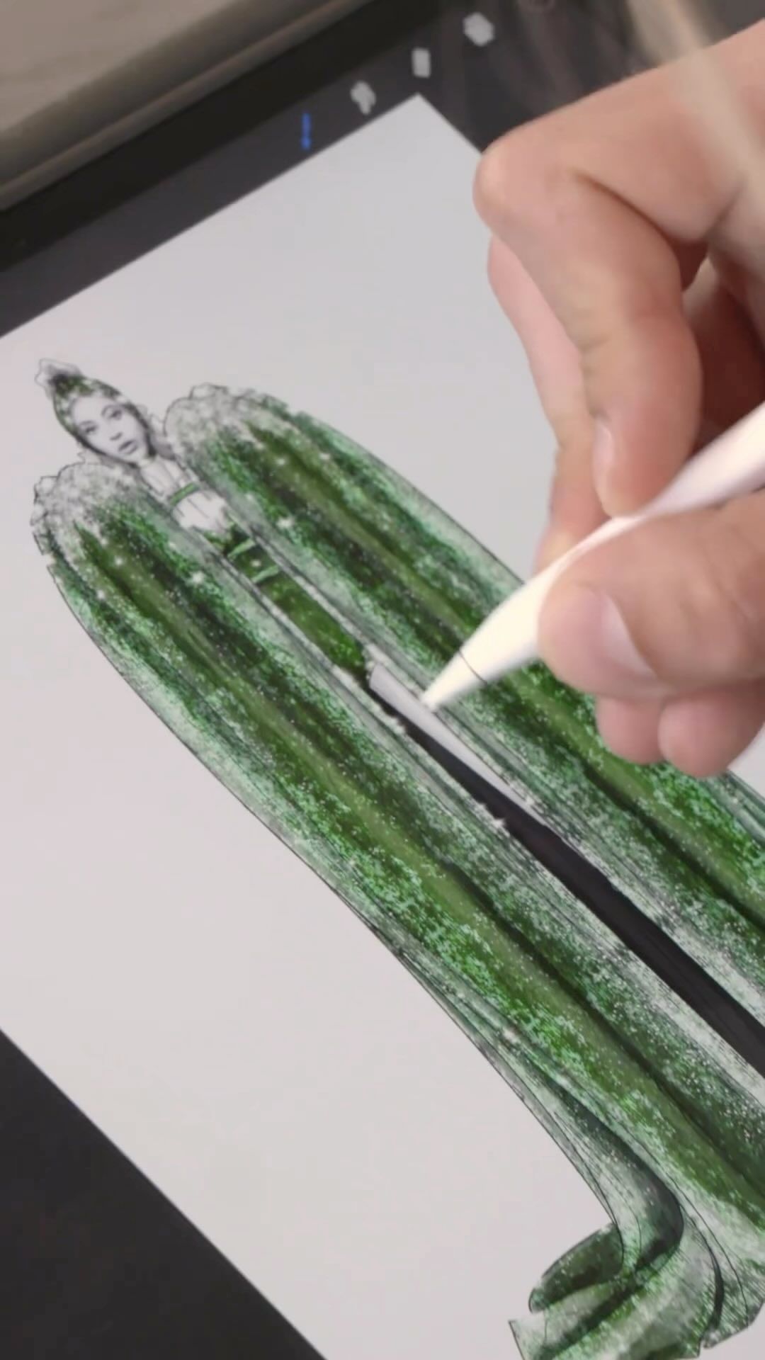 Fashion illustration on a digital tablet: hand drawing a woman's dress with a stylus in green and black, with white background.