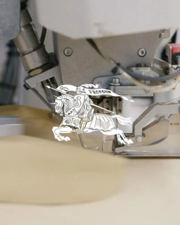 Close-up of a metal industrial machine featuring a graphic paper art image of a knight on horseback with a banner that reads 'PRORSUM'.