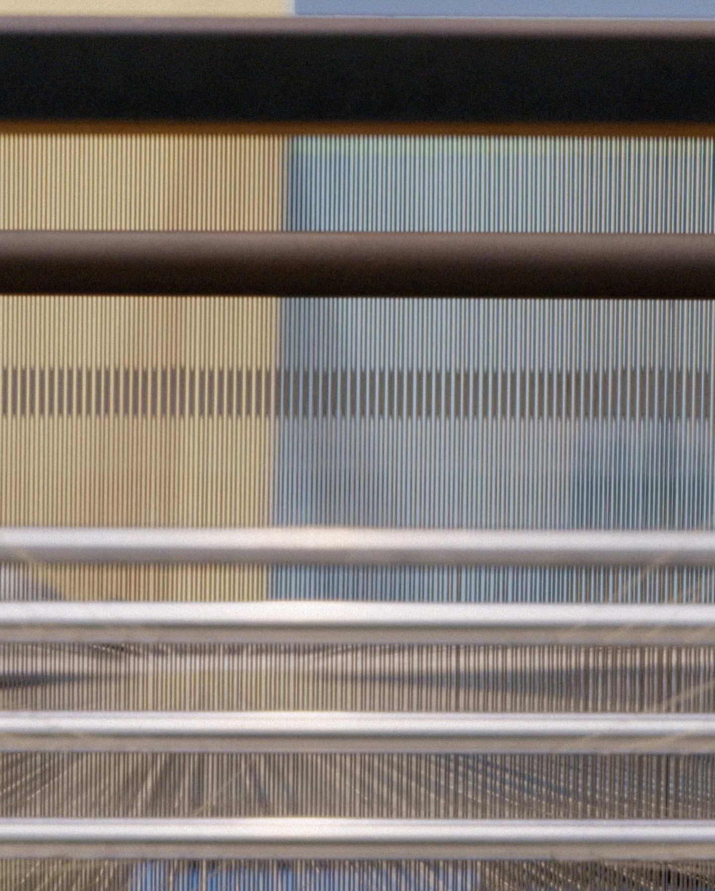Abstract image featuring parallel vertical lines in beige and blue hues, overlaid with horizontal metal rods creating a structured pattern.