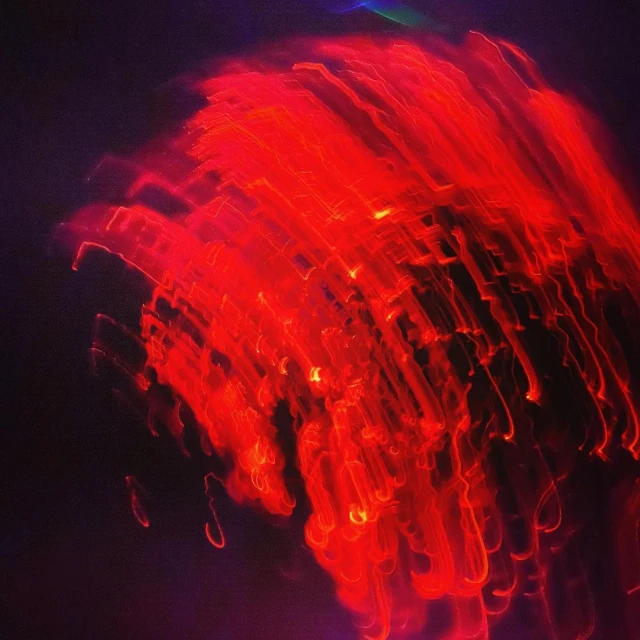 Abstract light painting photograph with glowing red streaks and a dark background, suitable for artistic and creative projects.