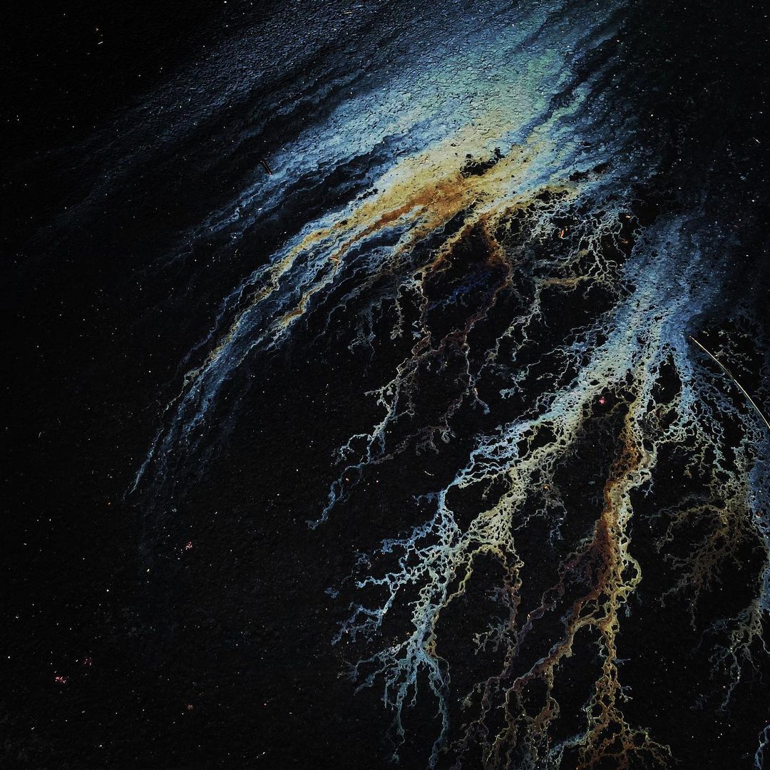 Abstract art featuring blue, gold, and white dendritic patterns on a dark background, resembling branching veins or lightning strikes.