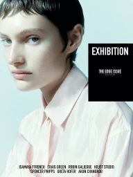 Close-up portrait of a model with short dark hair wearing a light pink button-down shirt against a pale background