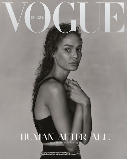 Vogue Greece cover featuring a woman with curly hair in a black two-piece outfit, posing with her hands near her face in a studio setting.