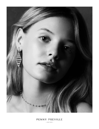 Close-up black and white portrait of a young woman wearing diamond drop earrings styled by Anna Katsanis.