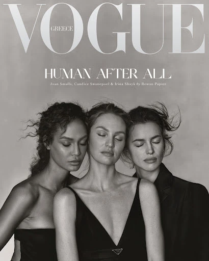 Black-and-white Vogue cover with three fashion models, Joan Smalls, Candice Swanepoel and Irina Shayk, eyes closed, in dresses and a blazer.