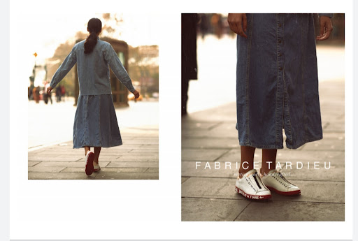 Woman in denim dress walks on city sidewalk, sneakers visible in close-up; Fabric TARDIEU text overlay. Fashion editorial photography.