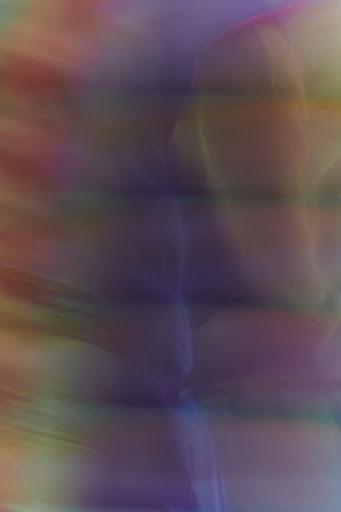 Abstract gradient background with blended hues of purple, pink, yellow, and green creating a soft, painterly effect in a vertical format.