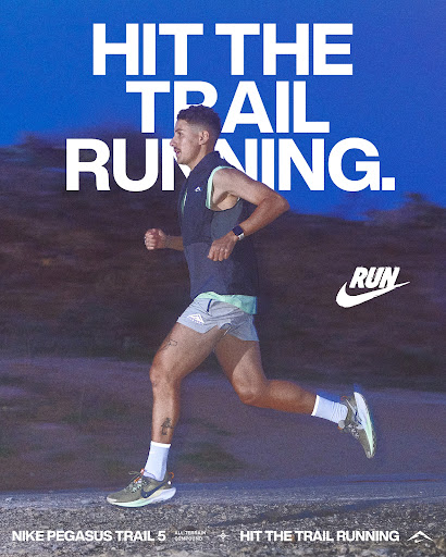 A male runner in sportswear runs on a trail in a Nike ad featuring the Nike Pegasus Trail 5 shoes, with text overlaying the scene.