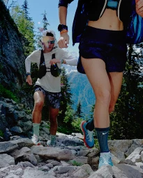 Two runners navigating a rocky mountain trail, styled by Charlotte Patterson with performance gear.