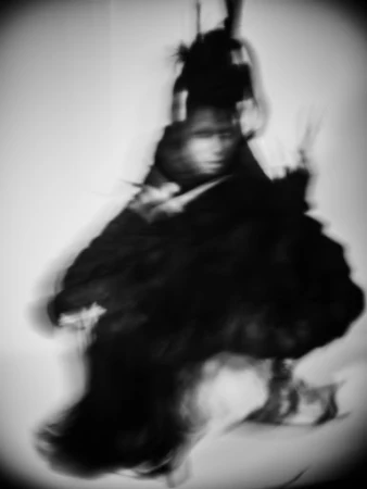 Abstract black and white portrait of a person with blurred motion, creating a sense of mystery and artistic expression.