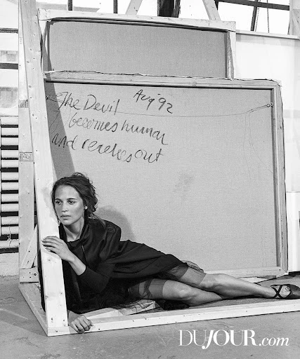 Woman lying in a wooden frame against a canvas with handwritten text in a black and white fashion editorial with edgy vintage vibes.