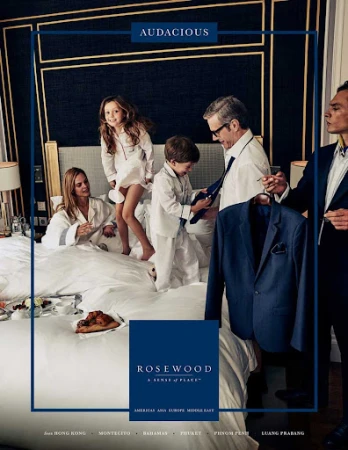 Rosewood Hotels ad features a family of five in a hotel room: mother, father, daughter, and two sons relaxing on a large bed.