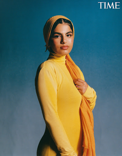 Portrait of a woman in a yellow dress and headscarf against a blue background, a scarf draped over her shoulder. TIME logo is visible.