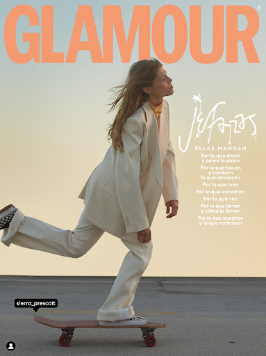 Magazine cover of woman skateboarding in suit. Glamour magazine cover featuring person in motion wearing a business suit on a skateboard.