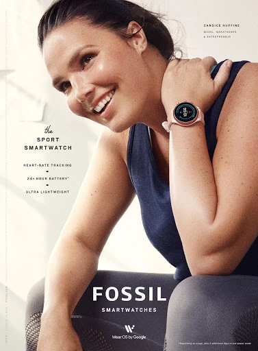 A woman smiles while showcasing a Fossil smart watch on her wrist, set against a bright backdrop with fitness-related promotional text.