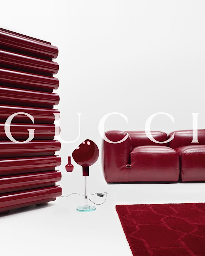 Contemporary red couch and lighting arrangement in a minimalist interior, evoking modern design and luxury furniture aesthetics.