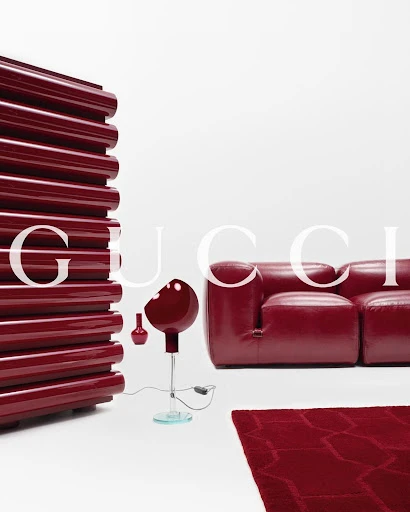 Contemporary red couch and lighting arrangement in a minimalist interior, evoking modern design and luxury furniture aesthetics.