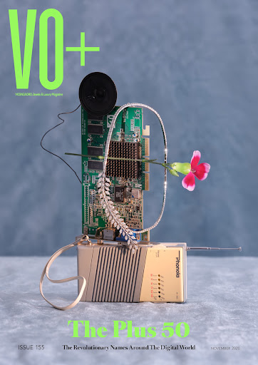 Magazine cover featuring vintage electronic devices, circuit board, jewelry, and flower against a hazy blue backdrop with neon green text.
