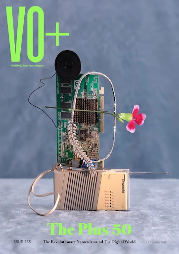 Magazine cover featuring vintage electronic devices, circuit board, jewelry, and flower against a hazy blue backdrop with neon green text.