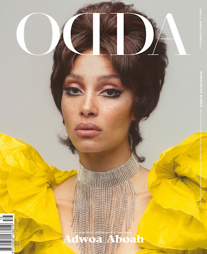 Close-up of Adwoa Aboah on magazine cover, wearing a yellow top with ruffles and a silver fringe necklace, against a gray background.