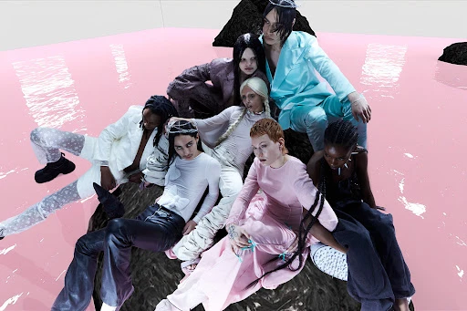 Editorial fashion shot of seven models of diverse ethnicities wearing stylish clothing and sitting on a dark surface against a pink backdrop.