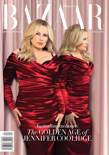Magazine cover featuring Jennifer Coolidge in a red dress, blonde hair, posing in front of a pink curtain with the magazine's title on top.