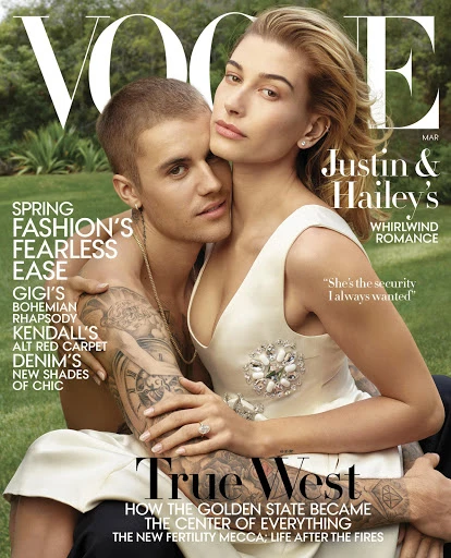 Vogue cover featuring Justin and Hailey Bieber. The couple poses outdoors against a green background.