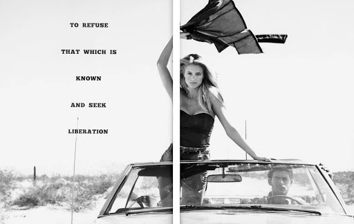 Black and white fashion shot in desert with woman standing in convertible waving fabric and man driving on a bright day.