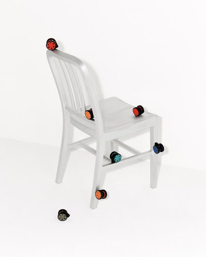 White chair adorned with colorful circular knobs against a clean white backdrop, creating a playful and modern design.
