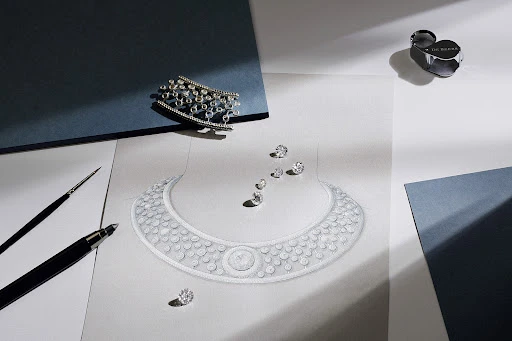 High-angle shot of an illustration of a diamond necklace, loose diamonds, jewelry, and drawing tools on a white and blue background.